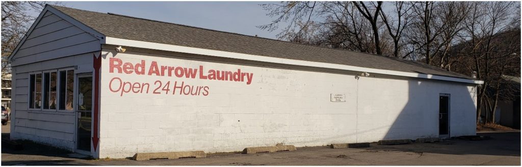 long blank wall for mural, words "red arrow laundry open 24 hours"