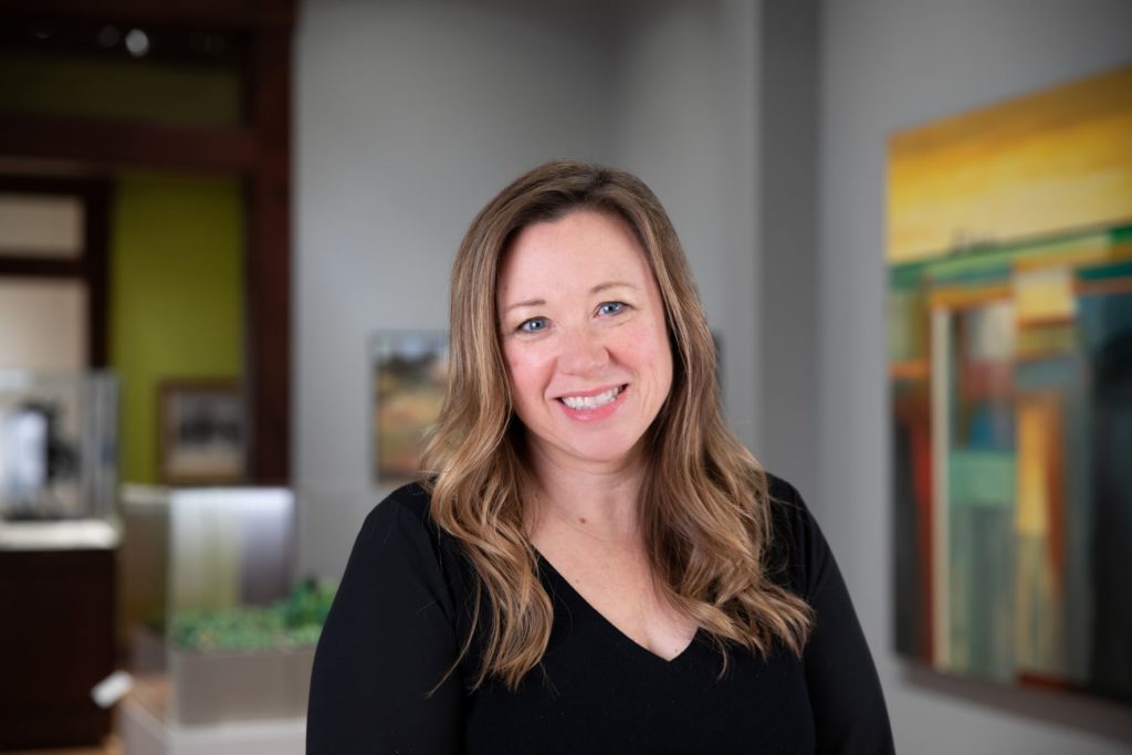 Headshot smiling woman in gallery