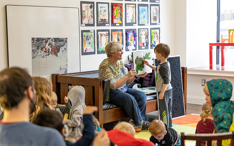 Photograph of librarian reading to a group of small children.